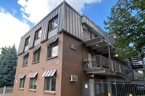 Denver apartment for rent - A modern building with a balcony and a gate.