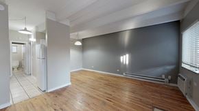 Denver apartment for rent - A room with wooden floors and a grey wall.