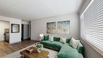 Denver apartment for rent - A living room with a green couch and a coffee table.