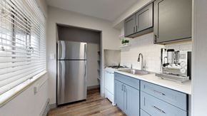 Denver apartment for rent - A modern kitchen with a stainless steel refrigerator and wooden flooring.