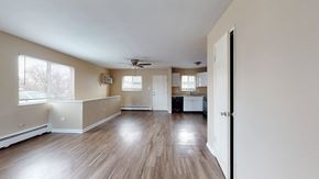 Lakewood apartment for rent - A spacious room with wood flooring and a ceiling fan.