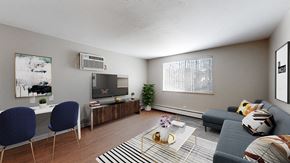 Denver apartment for rent - A living room with a grey couch, a coffee table, and a television.