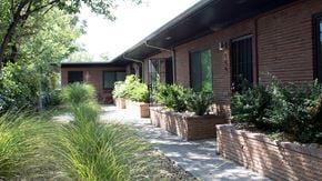 Denver apartment for rent - A house with a red brick exterior and a long driveway.