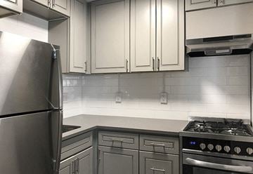 Denver apartment for rent - A kitchen with a stainless steel refrigerator and a stove with four burners.