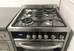 Denver apartment for rent - A modern gas stove with a digital display and six burners.