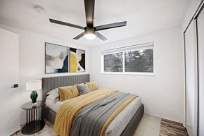 Denver apartment for rent - A bedroom with a bed, a ceiling fan, and a window.