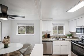Denver apartment for rent - A white kitchen with a table and chairs.
