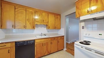 Wheat Ridge apartment for rent - A kitchen with wooden cabinets and a white stove.
