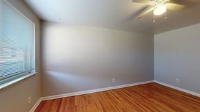 Wheat Ridge apartment for rent - A room with a ceiling fan and wooden flooring.