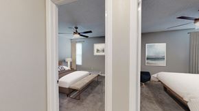 Lakewood apartment for rent - A bedroom with a bed, chair, and a ceiling fan.