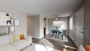 Lakewood apartment for rent - A living room with a white couch and a dining table with chairs.