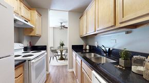 Denver apartment for rent - A kitchen with wooden cabinets and black countertops.
