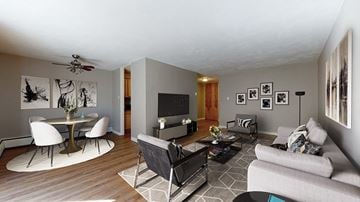Denver apartment for rent - A living room with a grey couch, a white table and a television.