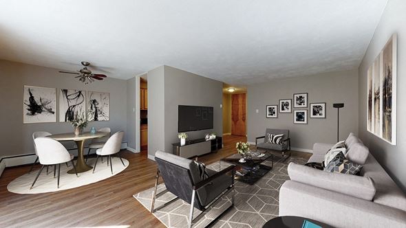 Denver apartment for rent - A living room with a grey couch, a white table and a television.