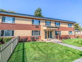 Lakewood apartment for rent - A red brick building with a green lawn in front.