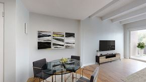 Golden apartment for rent - A modern dining room with a glass table and chairs.