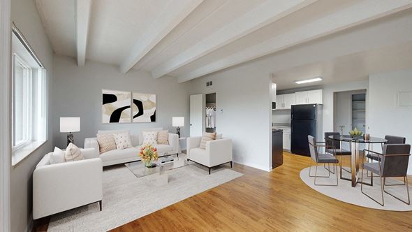 Golden apartment for rent - A modern living room with white furniture and a wooden floor.