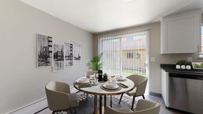 Wheat Ridge apartment for rent - A dining room with a table set for four and a plant on the windowsill.