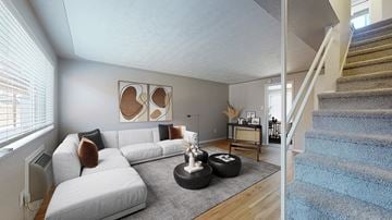 Wheat Ridge apartment for rent - A living room with a white couch and a blue carpeted staircase.