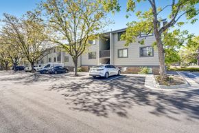 Arvada apartment for rent - A car is parked in a parking lot in front of a building.