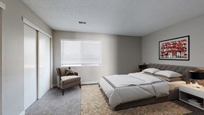 Arvada apartment for rent - A bedroom with a large bed and a chair by the window.