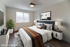 Denver apartment for rent - A bedroom with a large bed and a ceiling fan.