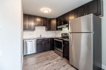 Denver apartment for rent - A modern kitchen with dark wood cabinets and stainless steel appliances.