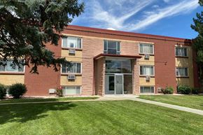 Lakewood apartment for rent - A red brick building with a green lawn in front.