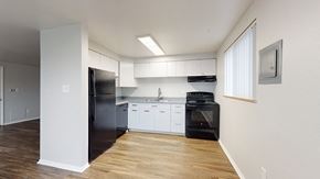 Lakewood apartment for rent - A kitchen with black appliances and white cabinets.