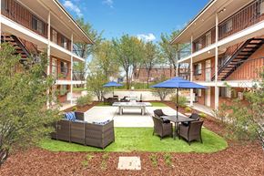 Lakewood apartment for rent - A courtyard with a table and chairs surrounded by buildings.