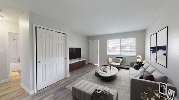 Lakewood apartment for rent - A modern living room with a grey sofa and a white door.