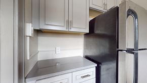 Denver apartment for rent - A black refrigerator stands next to a stainless steel dishwasher in a kitchen.
