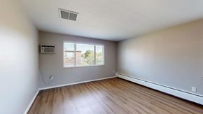 Lakewood apartment for rent - A room with wooden flooring and a window with blinds.