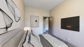 Denver apartment for rent - A modern bedroom with a bed and a painting on the wall.