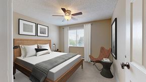 Englewood apartment for rent - A bedroom with a bed, chair, and pictures on the wall.