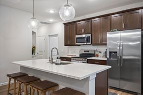 Stow townhouse for rent - A kitchen with a white countertop and brown stools.