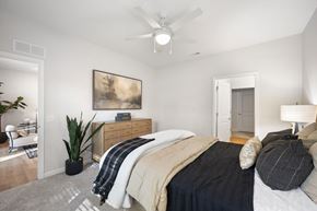Stow townhouse for rent - A bedroom with a bed, a ceiling fan, and a painting on the wall.