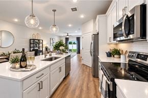 Hinckley apartment for rent - A modern kitchen with white cabinets and a black stove top.