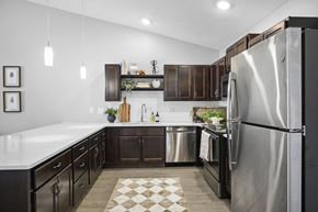 Strongsville apartment for rent - A modern kitchen with a stainless steel refrigerator and dark wood cabinets.