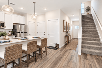 Milton apartment for rent - A kitchen with white cabinets and a dining table with chairs.