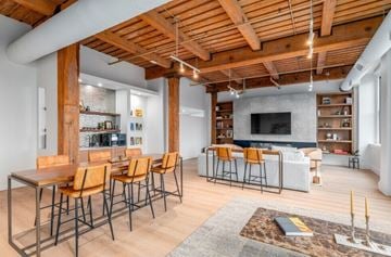 Cleveland apartment for rent - A modern living room with a wooden ceiling and a long table with chairs.