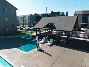 Salem apartment for rent - A pool with a pavilion and chairs in front of apartment buildings.at Eastpark Apartment Homes, Oregon, 97301