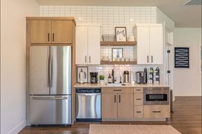 Albany apartment for rent - A kitchen with a refrigerator, cabinets, and a tiled backsplash at Timberridge Place Apartment Homes, Oregon, 97322