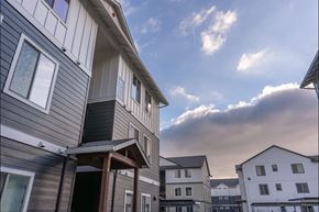 Woodburn apartment for rent - A row of houses with a cloudy sky above them at Woodburn Place Apartment Homes, Woodburn
