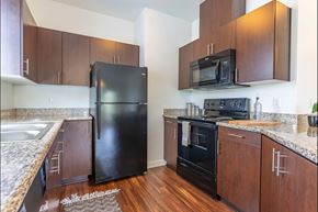 Independence apartment for rent - A kitchen with a black refrigerator and black oven at Riverplace Apartment Homes, Independence, OR