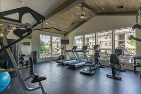 Sandy apartment for rent - A gym with a variety of equipment including treadmills, weights, and a stationary bike at Sandyplace Apartment Homes, Sandy, OR, 97055