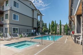 Silverton apartment for rent - A swimming pool surrounded by lounge chairs and apartment buildings at Silverplace Apartment Homes, Oregon, 97381
