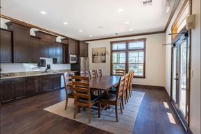 Molalla apartment for rent - A kitchen with dark wood cabinets and a dining table with chairs at Stoneplace Apartment Homes, Molalla