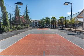 Molalla apartment for rent - A tennis court with a net and a building in the background at Stoneplace Apartment Homes, Molalla, 97038