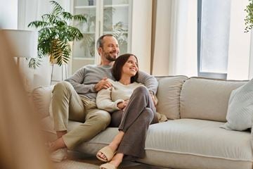 Hermiston apartment for rent - A man and woman are sitting on a couch, holding hands and smiling at each other.